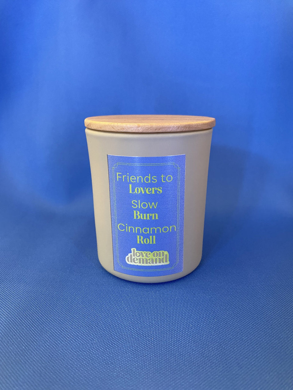 Candle with a wooden lid on a blue background