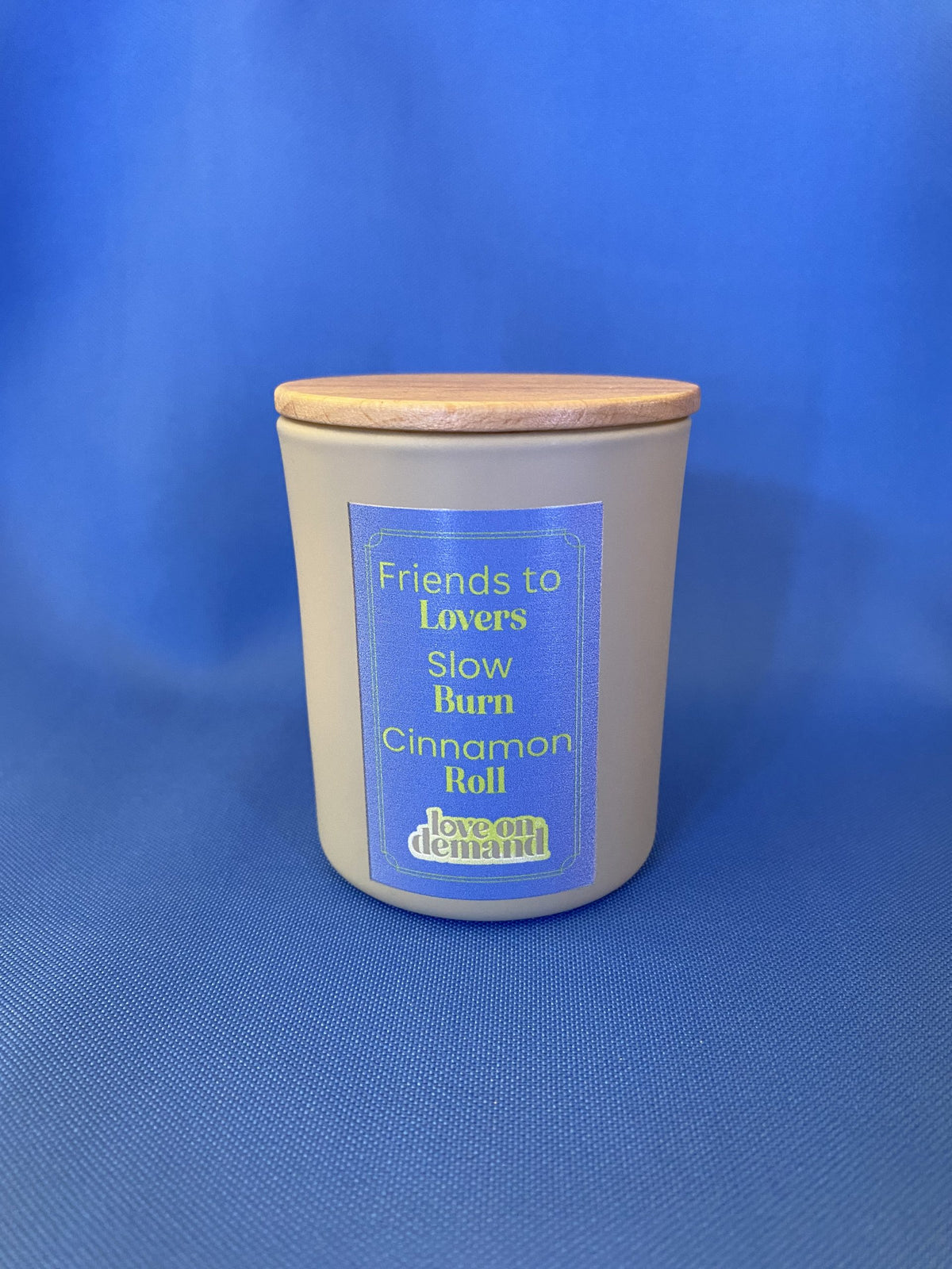 Candle with a wooden lid on a blue background